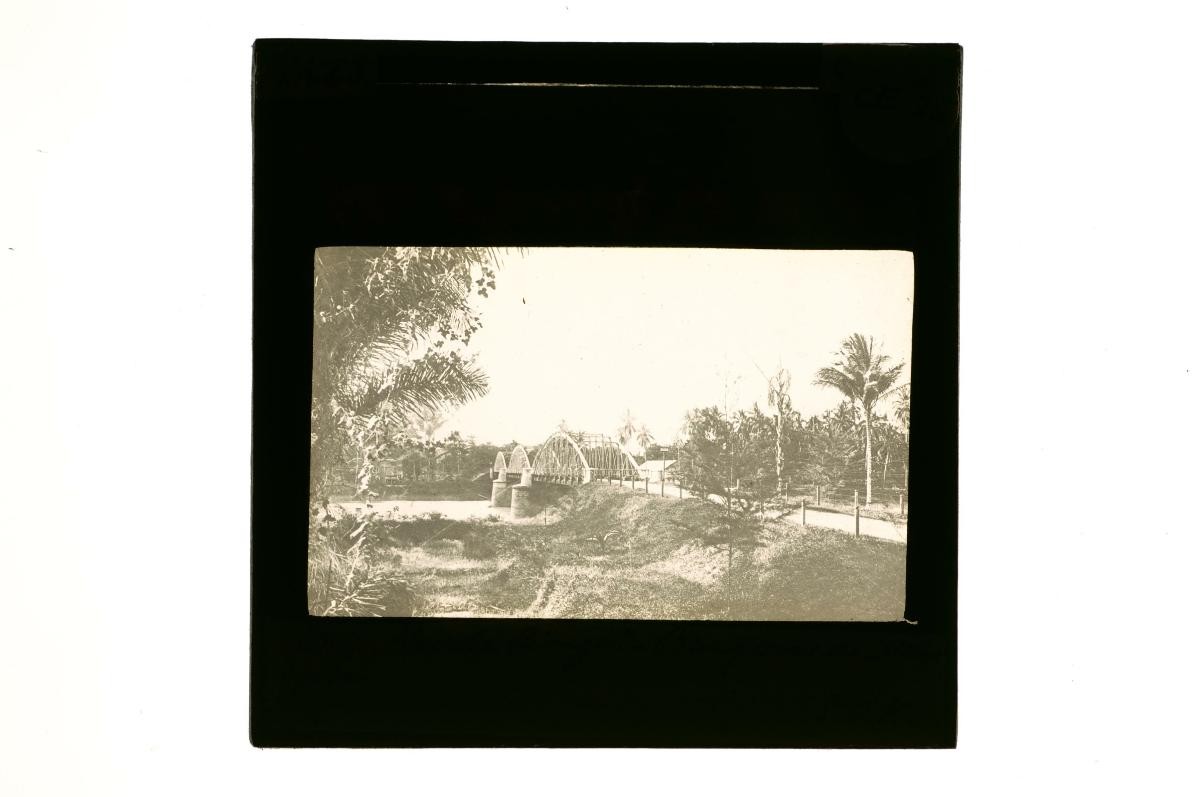 A glass lantern slide depicting a railway bridge built over a river