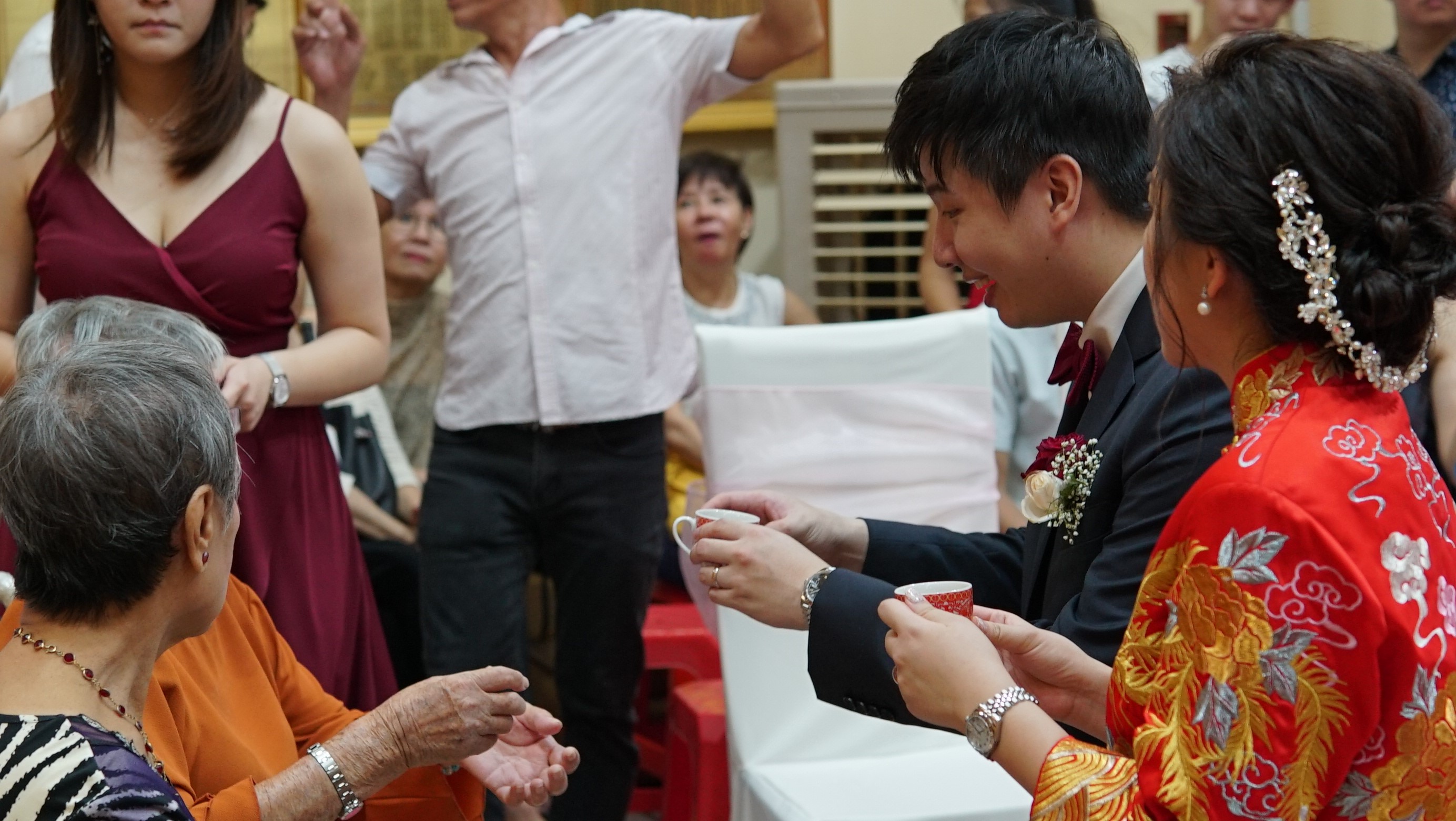 The wedding couple serving tea to the elders of the family as part of the tea ceremony. The elders give their blessings in return.
