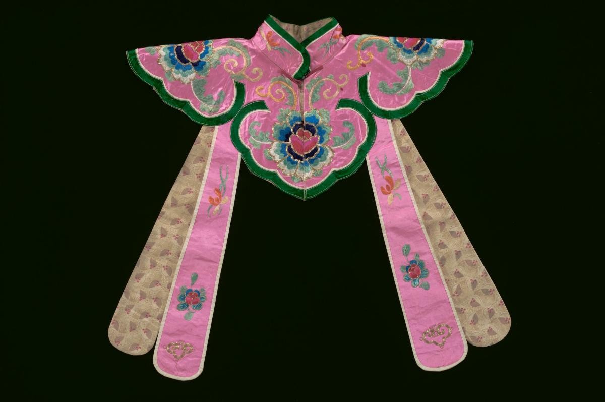 A pink shoulder piece with floral embroidery worn in a Chinese opera