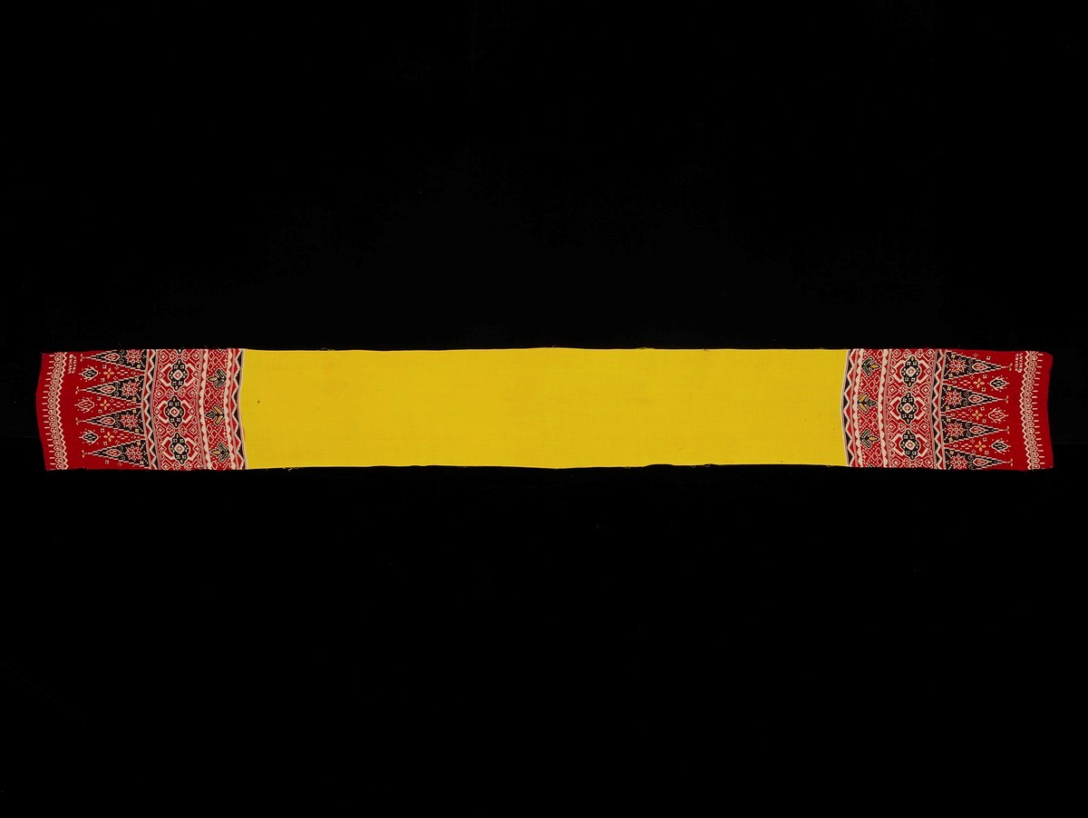 A yellow scarf 'sampur' with 'polos' and red 'tumpalan' design.