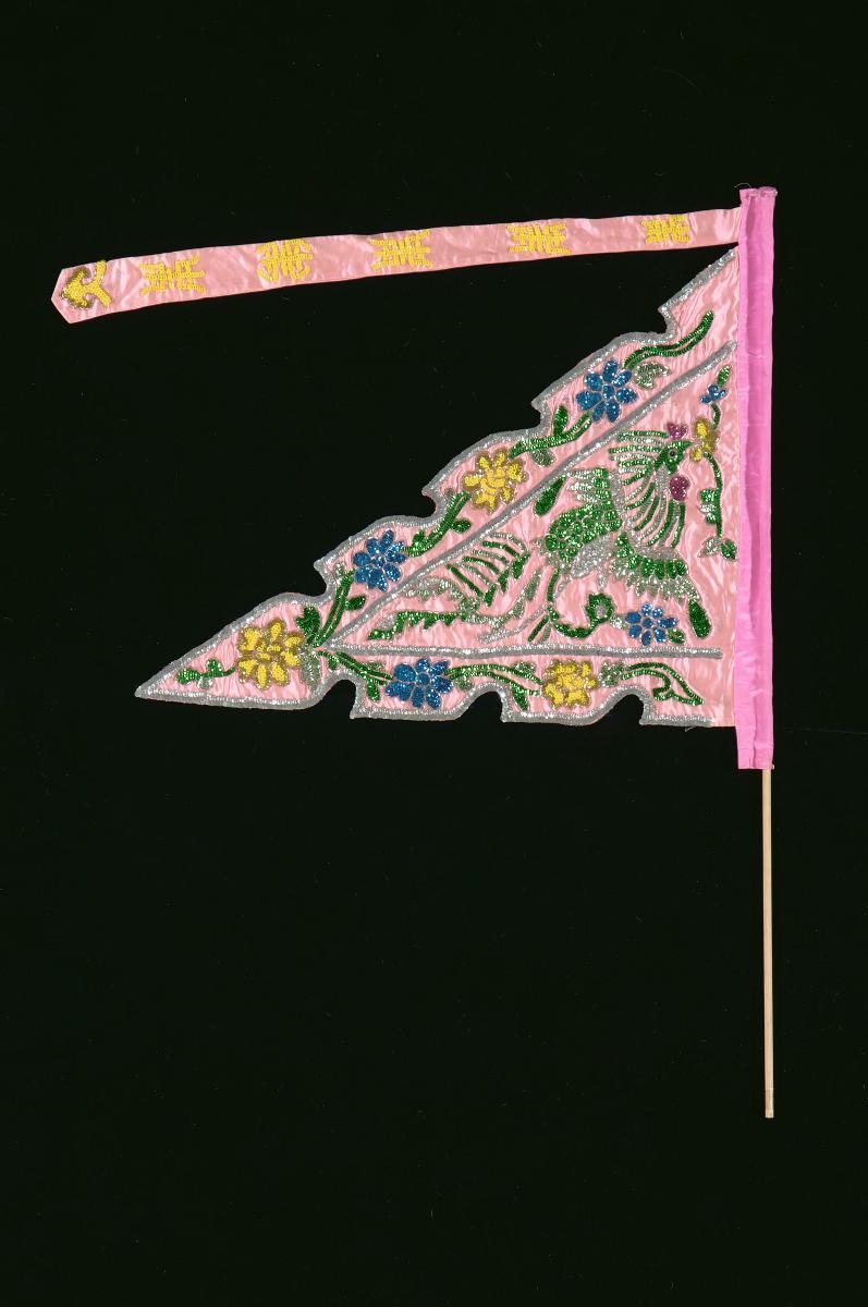 A pink triangular pennant worn by a ‘dao ma dan’ in a Chinese opera
