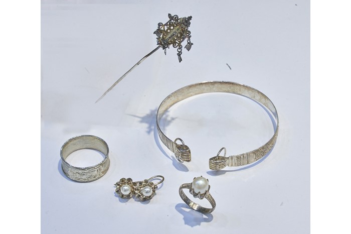 These burial accessories, sold by Kim Poh Hong in the 1950s, include (clockwise from the top) Di Zhang Wang’s (Ksitigarbha Bodhisattva) sceptre, Buddha’s hands bangle, a pair of earrings, a ring inset with pearls and <em>chap sa gor </em>(13-band ring), which represents the lunar months in a year.