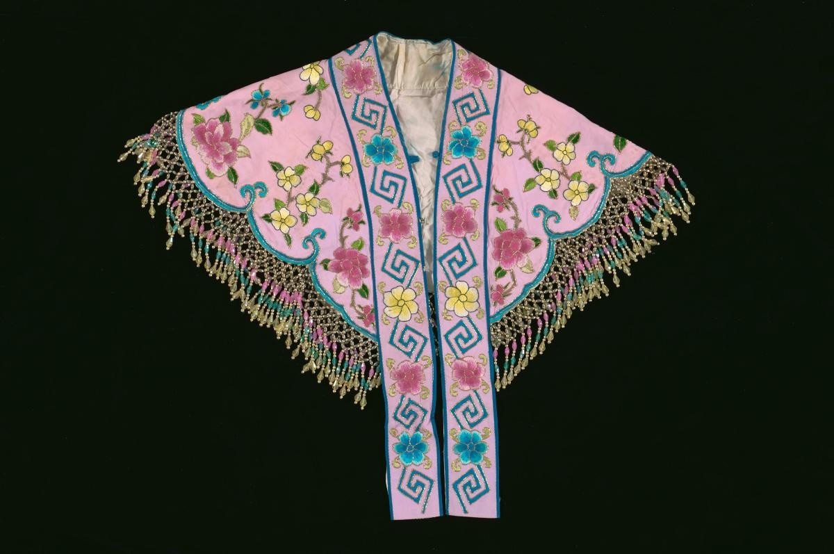A pink shoulder piece with floral embroidery and sequins worn by a ‘hua dan’ in a Chinese opera