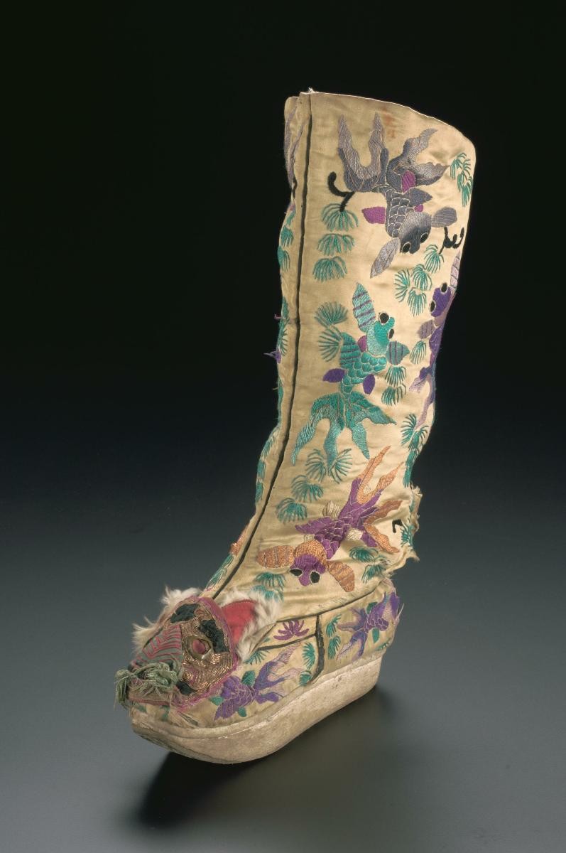 A platform boot with embroidered goldfish motifs worn in a Chinese opera performance