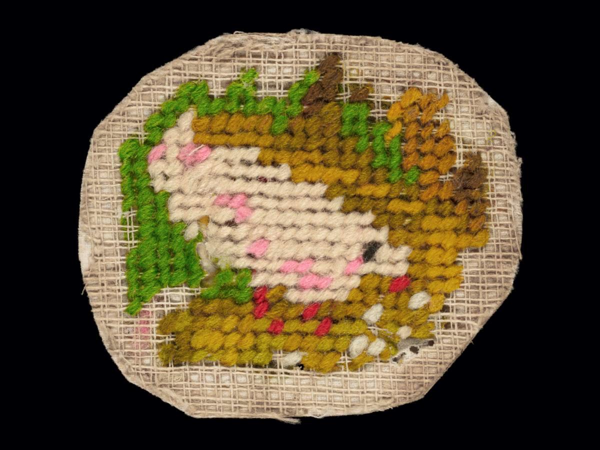Needlework sampler with motifs of a bird and greenery