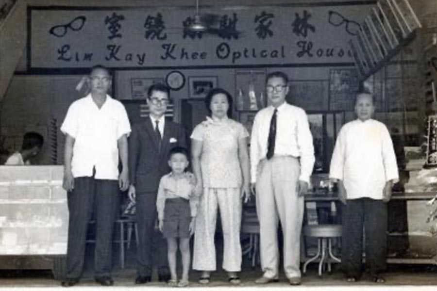 1960年,林家骐(右二)和他的妻子翁莲娟(右三),在眼镜店的开业典礼上留影。照片中的小男孩SS Lim是林家骐的第五个孩子,他现在和他姐妹凯伦(Karen)和多丽斯(Doris)一起经营这家眼镜店。