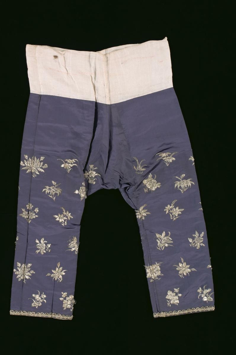 A pair of purple trousers with gold floral motifs worn in a Chinese opera performance