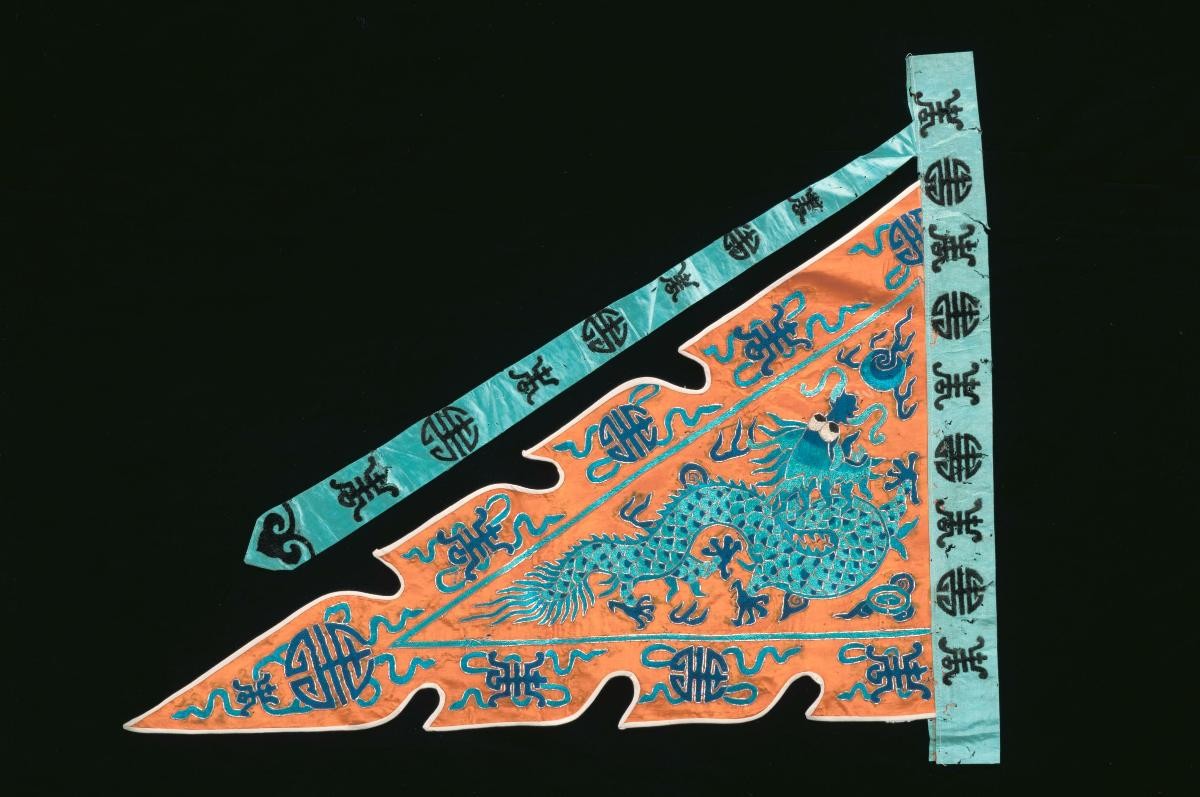 An orange embroidered triangular pennant worn by a ‘wu sheng’ in a Chinese opera