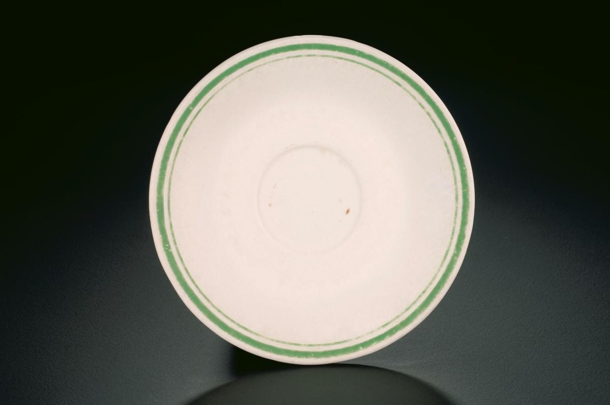 White porcelain saucer with green rim