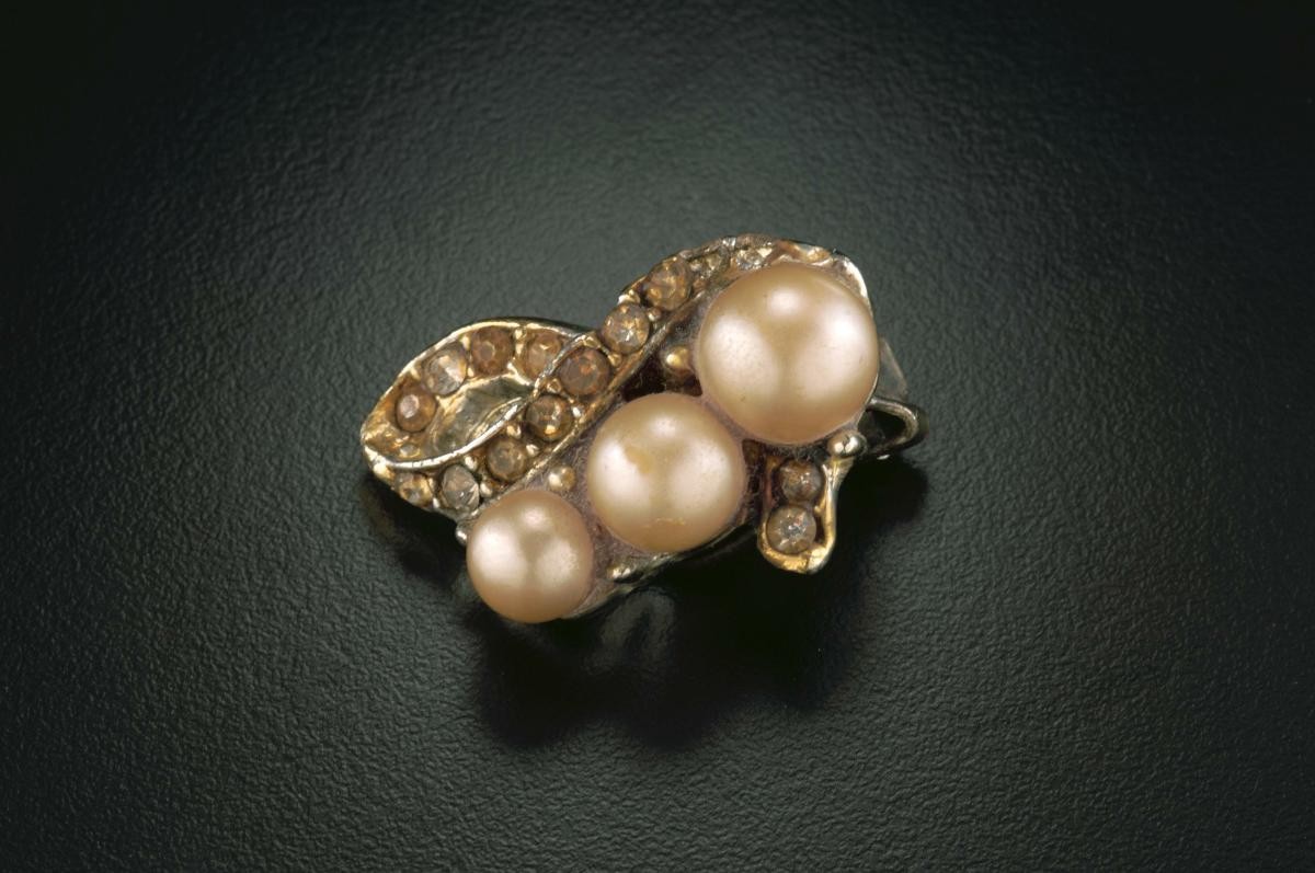 A pair of clip-on ear rings with red beads and pearls that belonged to a notable women's rights activist