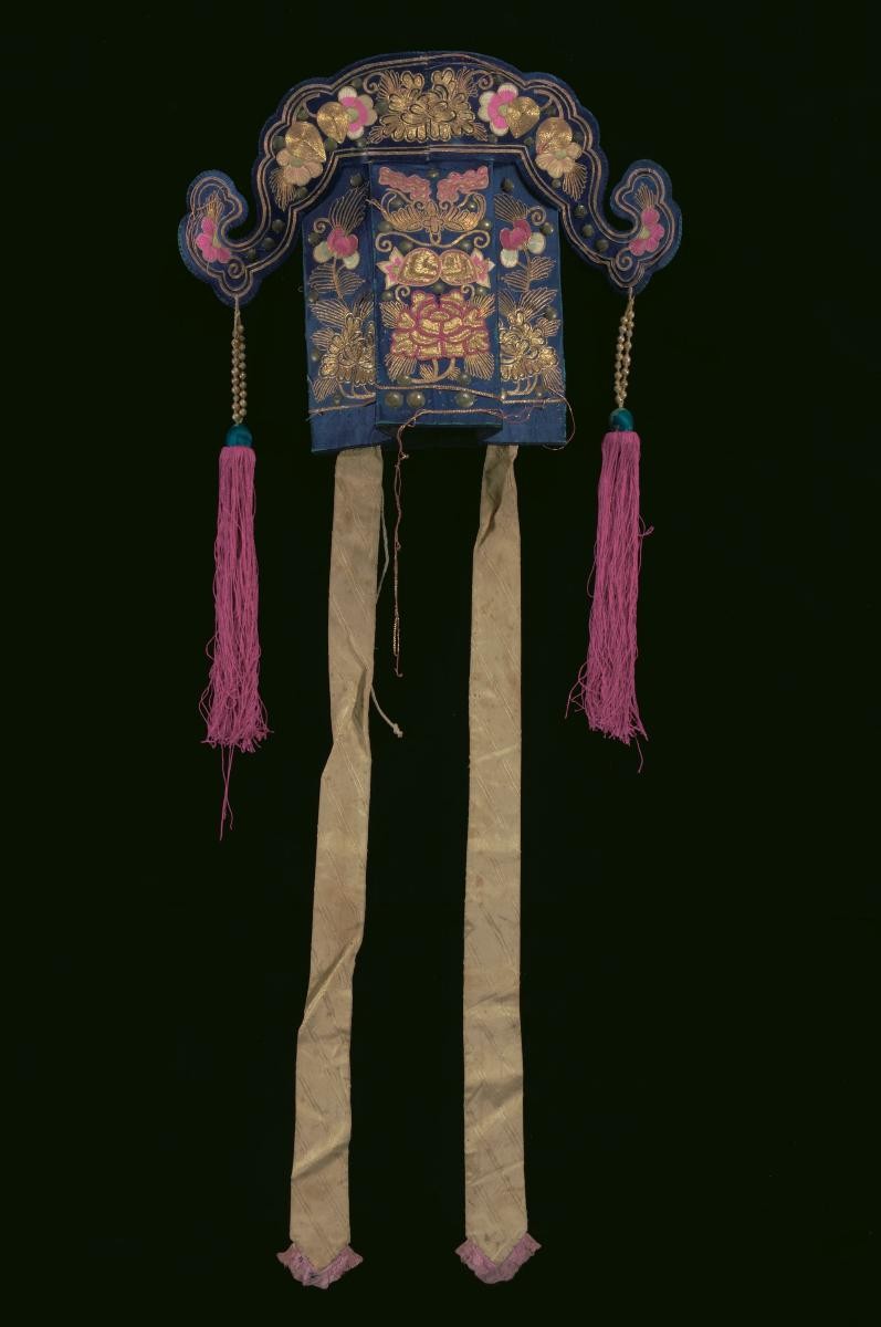 A violet hat with gold embroidered floral motifs and purple tassels worn by a ‘wen xiao sheng’ in a Chinese opera