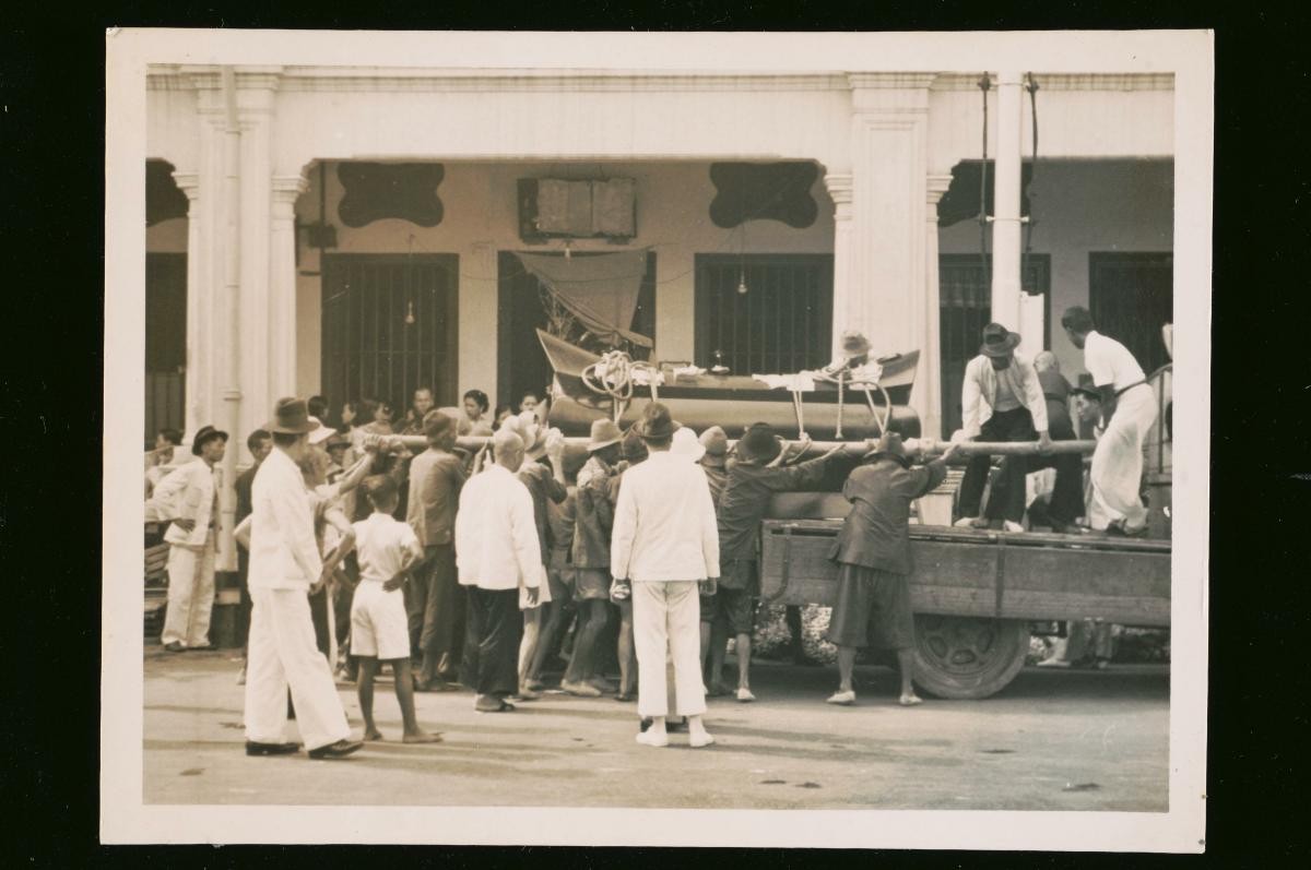A Chinese coffin being loaded onto a truck