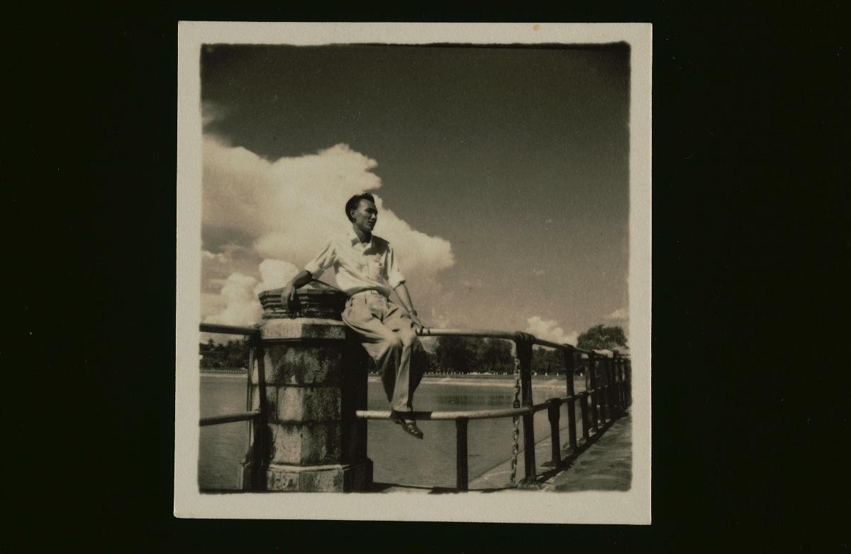 Si Jing’s husband, Huang Da Li, sitting on a railing