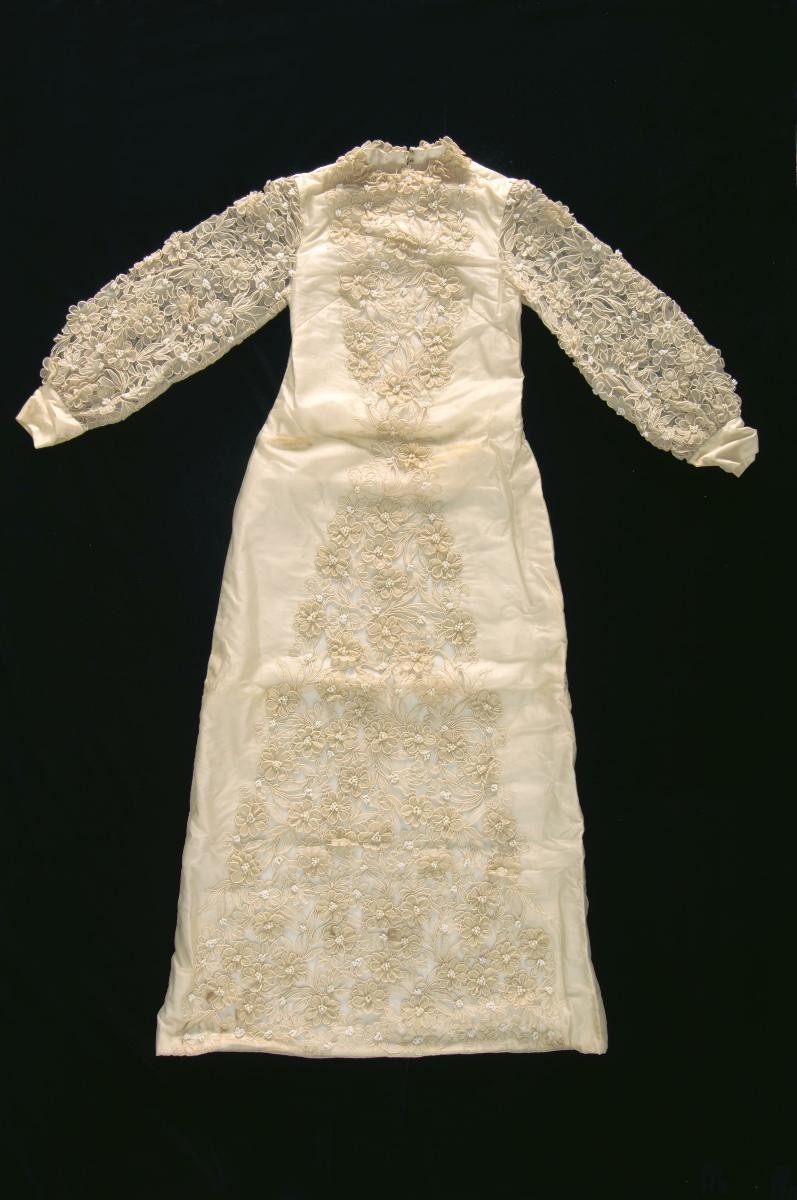 A cream long-sleeved wedding dress with floral embellishments
