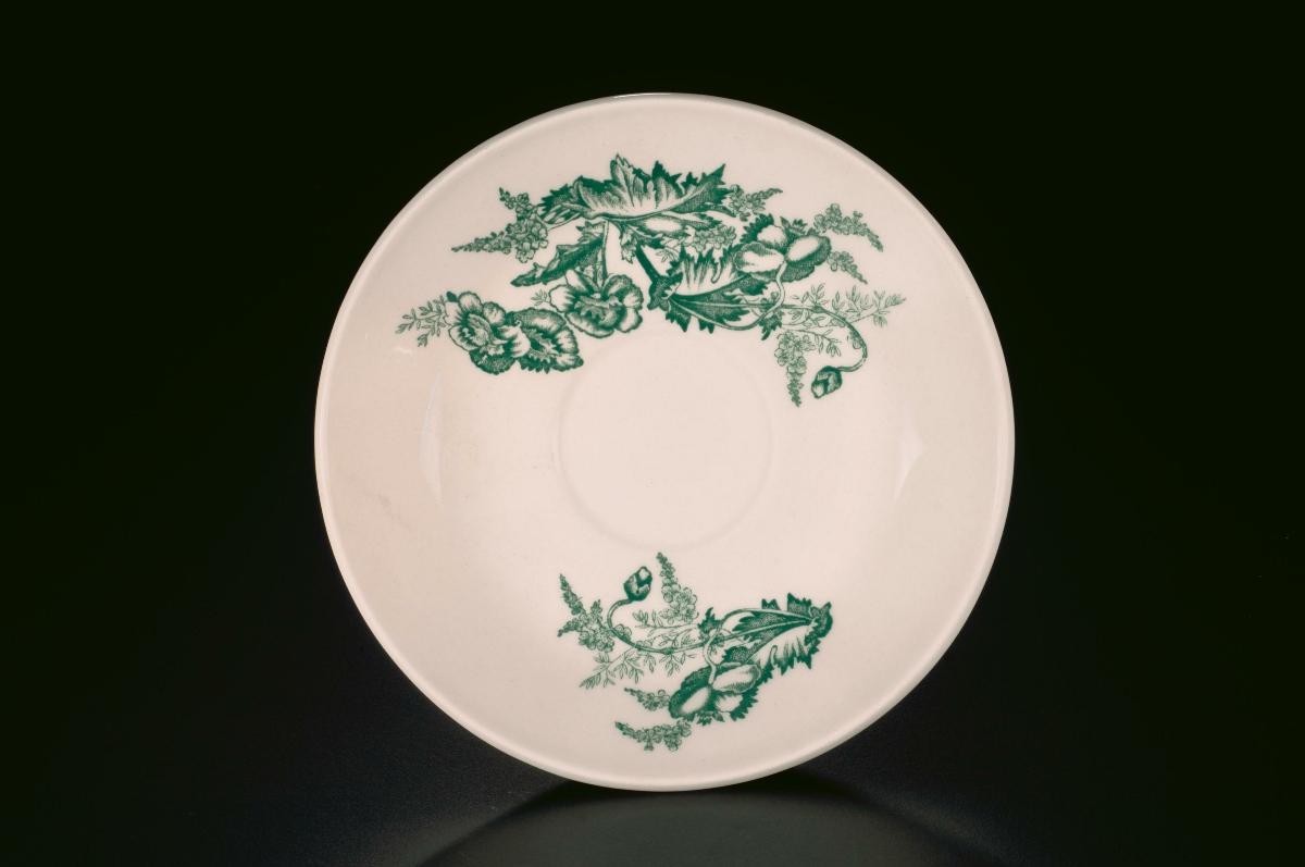 White porcelain saucer with green floral motif