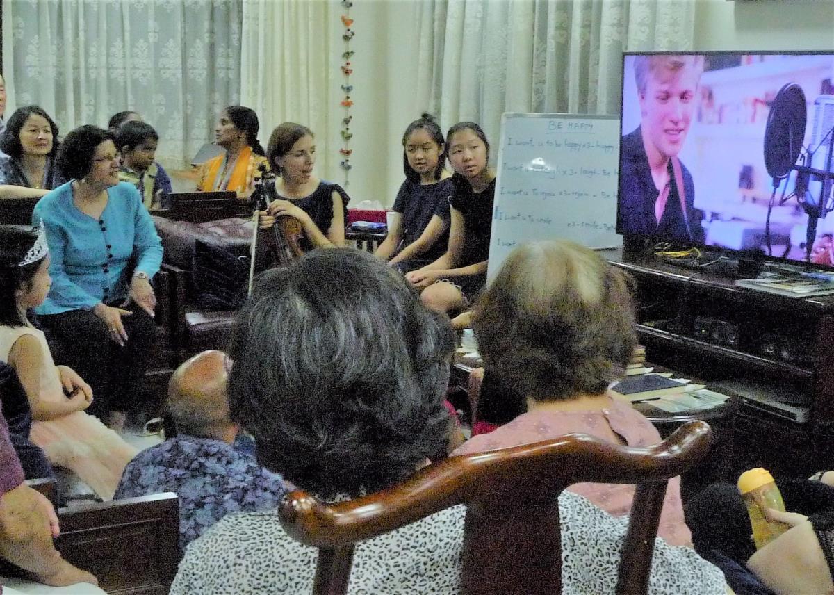 Bahá'í faithful learns a new devotional song at a Nineteen Day Feast.