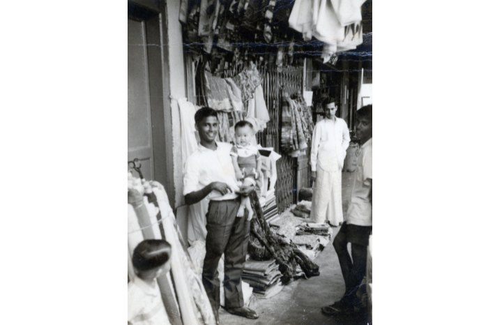 Gambar yang diambil pada tahun 1962 ini menunjukkan pengasas O. K. Mohammed Haniffa (di tengah gambar) berdiri di sebelah gerainya di tepi jalan di Campbell Lane.