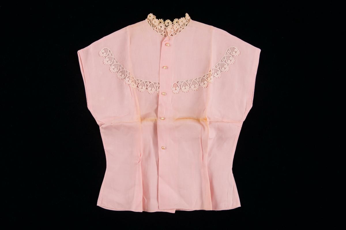 A sleeveless pink blouse with lace trimmings