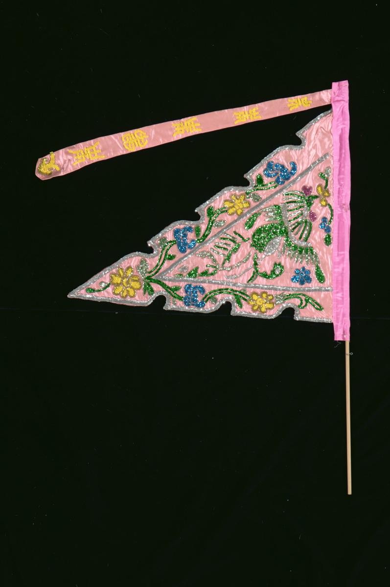 A pink triangular pennant worn by a ‘dao ma dan’ in a Chinese opera