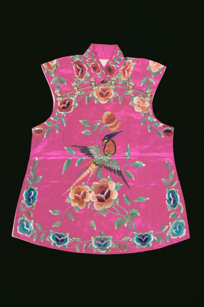 A pink sleeveless top with embroidered bird and floral motifs worn in a Chinese opera
