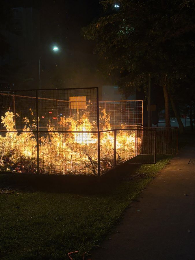 Burning of paper offerings for the deceased at a Taoist funeral.