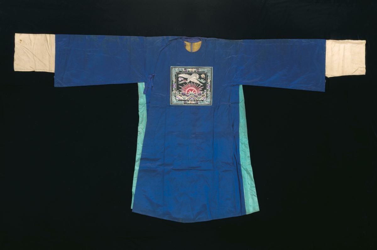 A dark blue robe with a black insignia worn by a court official in a Chinese opera