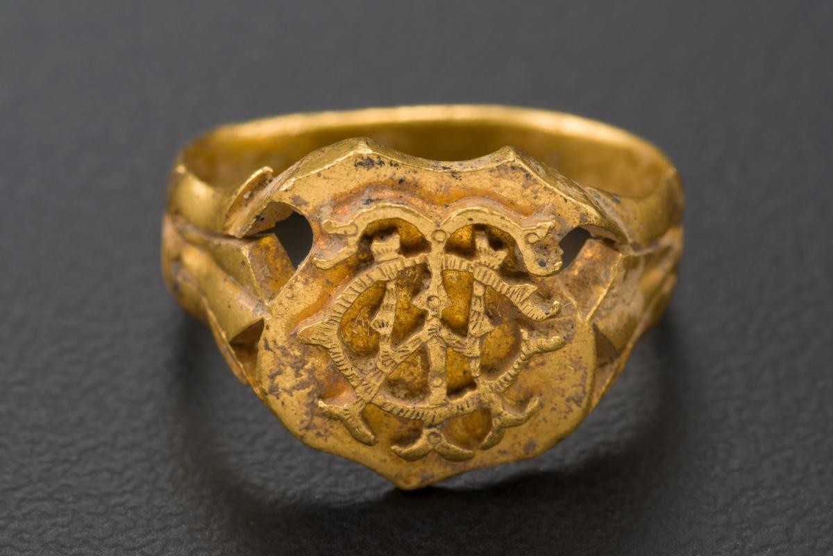 A gold ring with a crest