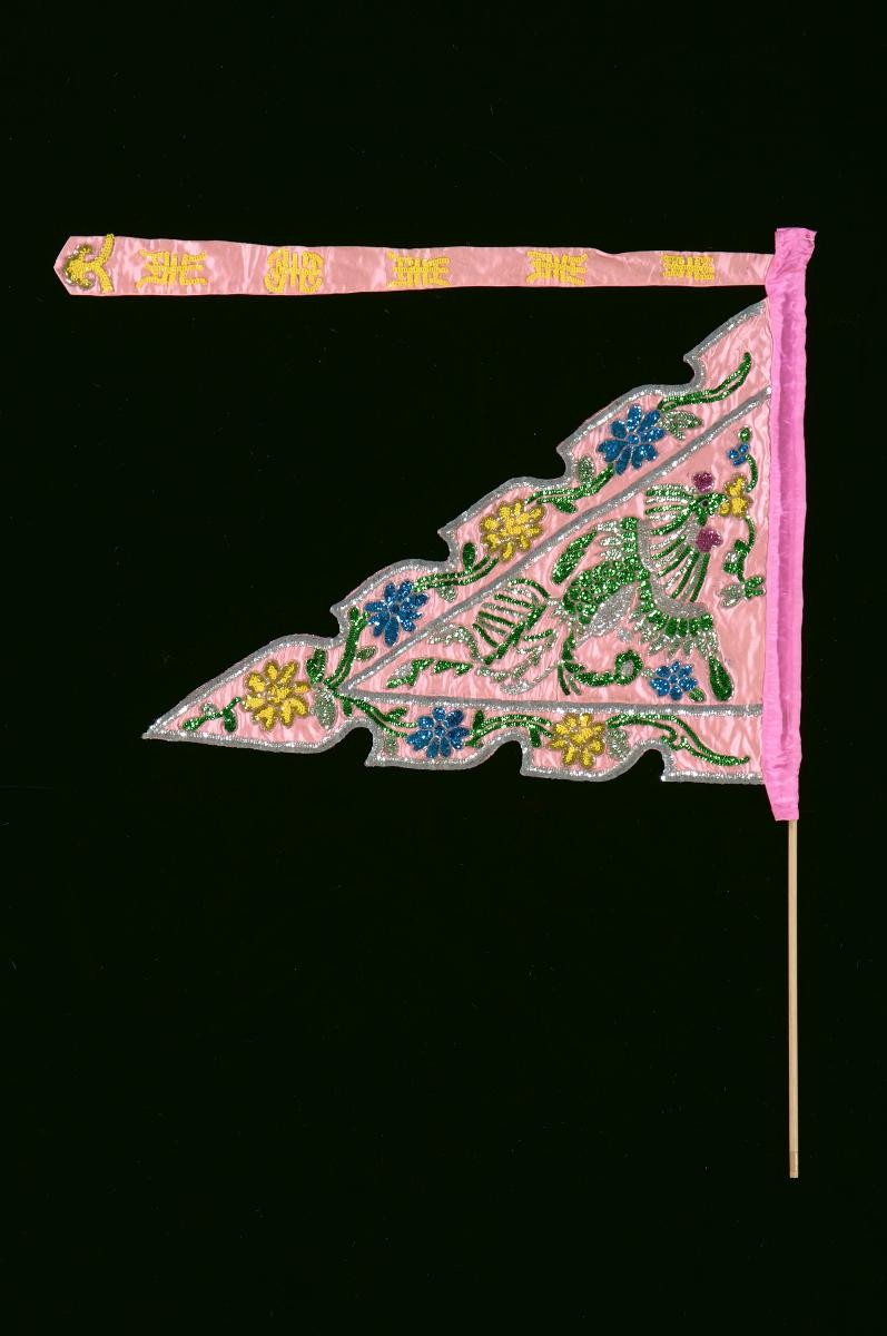 A pink triangular pennant worn by a ‘dao ma dan’ in a Chinese opera