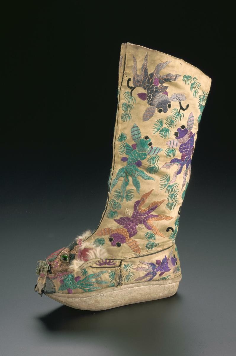 A platform boot with embroidered goldfish motifs worn in a Chinese opera performance