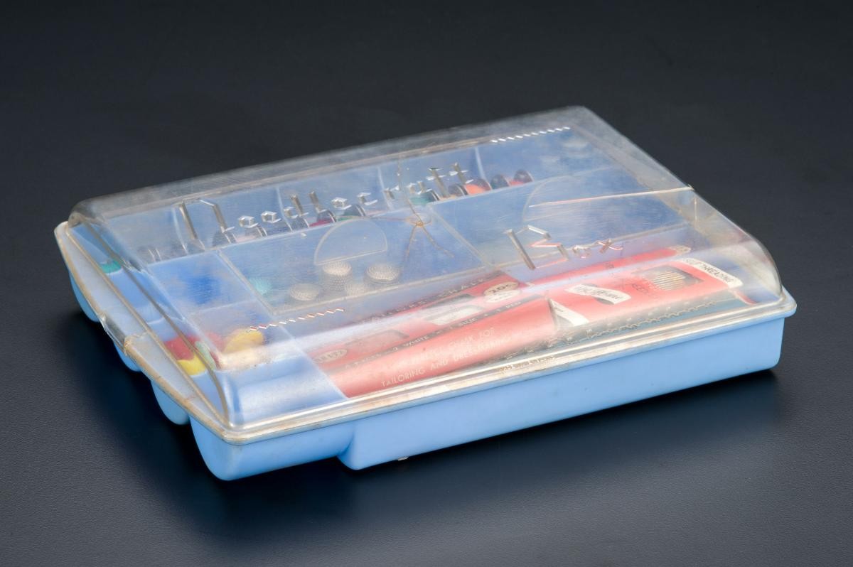 A Needlecraft Organiser plastic box and an assortment of sewing tools